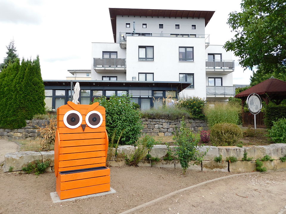 alt="Fassade mit dem Garten"